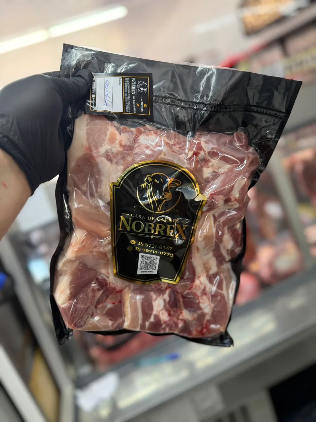 O mesmo tipo de corte em embalagem personalizada com a marca, o contato e o QR code do açougue impressos